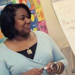 Woman teaching children in a colorful classroom.