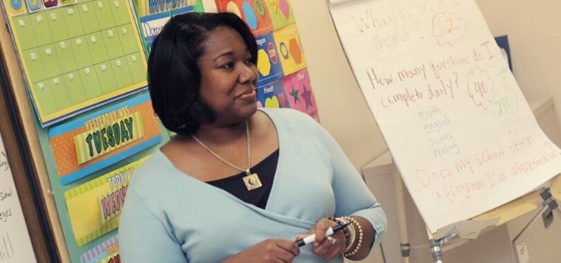 Woman teaching children in a colorful classroom.
