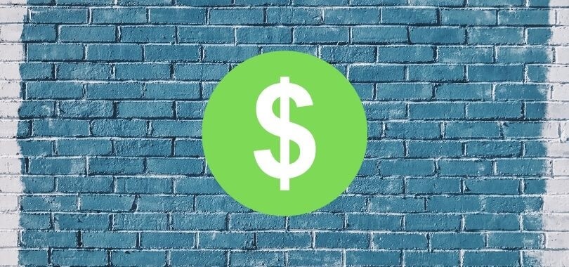 Dollar sign on a brick college wall.