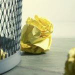 Balled up tests thrown into a wastebasket.