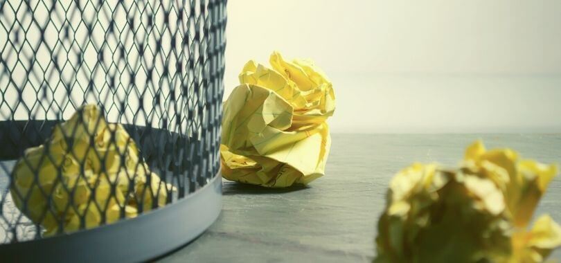 Balled up tests thrown into a wastebasket.