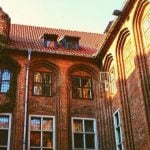 A brick college building covered in ivy.