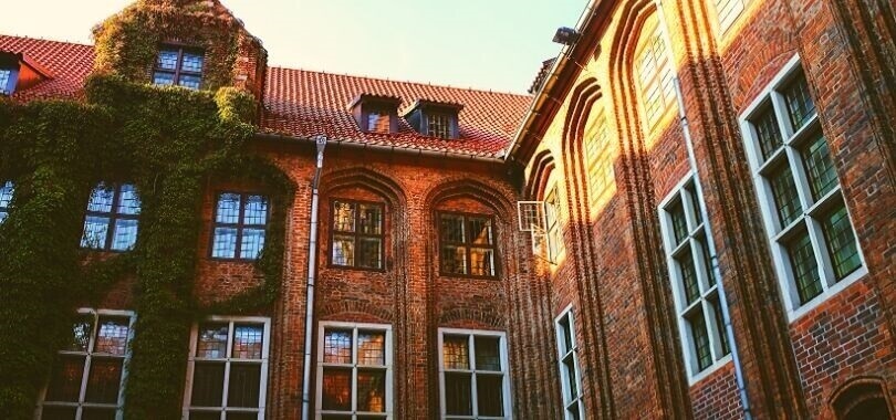 A brick college building covered in ivy.