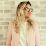 College student leaning against the wall of her college career center.