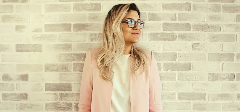 College student leaning against the wall of her college career center.