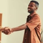 student shaking hands with college official