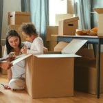 Parents playing in moving boxes with their daughter. They're thinking about 529 savings plans for her future education.