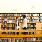 Two students standing in their liberal arts college library